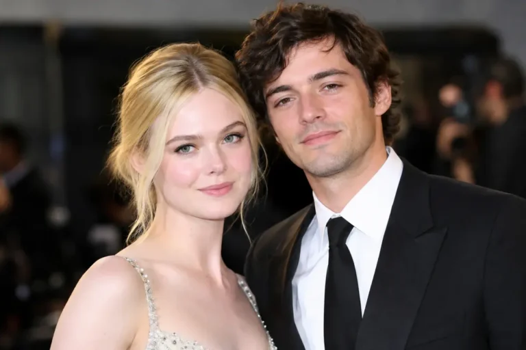 Elle Fanning and a male companion posing together at a glamorous red carpet event.